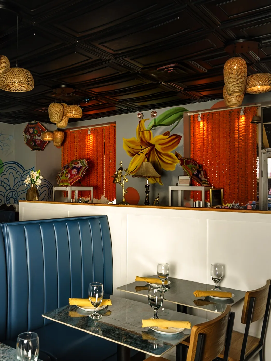 A set table in Lilly's dining room under the marigold garlands and lily mural